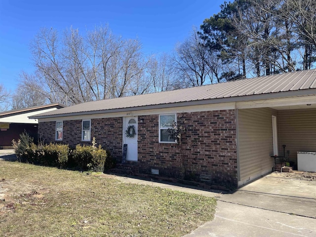 ranch-style home featuring metal roof, an attached carport, brick siding, crawl space, and a front yard