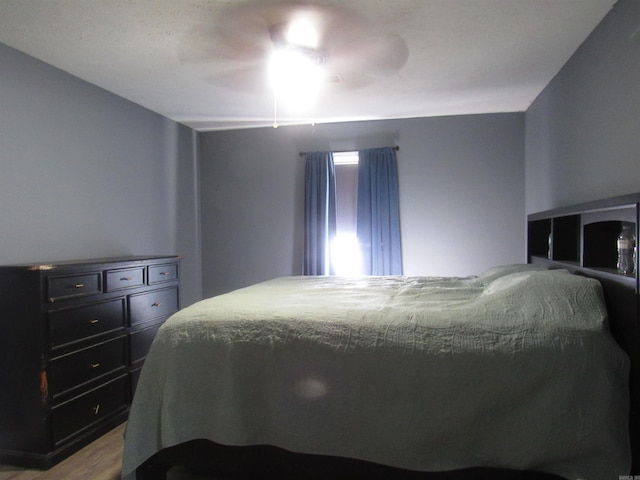 bedroom with a ceiling fan and light wood-style flooring