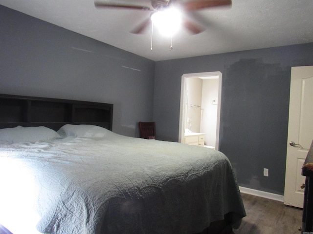 bedroom featuring dark wood-style floors, ceiling fan, ensuite bathroom, and baseboards