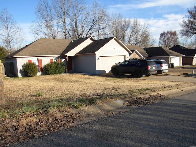 ranch-style home featuring a garage, driveway, and a front yard