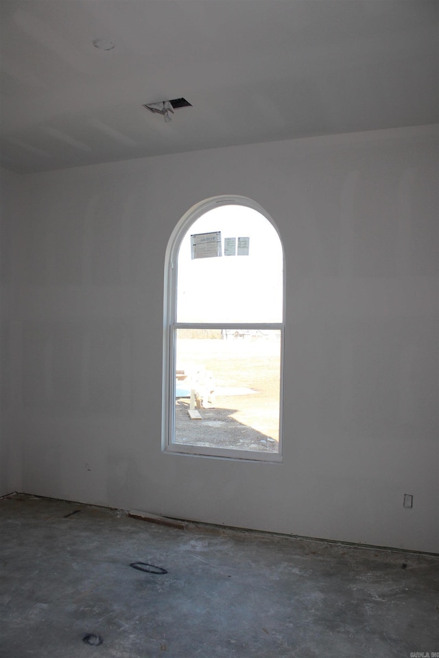 empty room with concrete flooring and visible vents