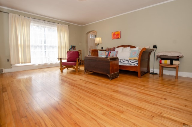 bedroom featuring light wood-style floors, visible vents, arched walkways, and ornamental molding