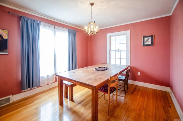 dining area with a healthy amount of sunlight, wood finished floors, and crown molding