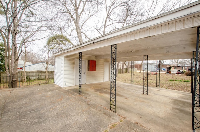 exterior space featuring a carport, fence, and driveway