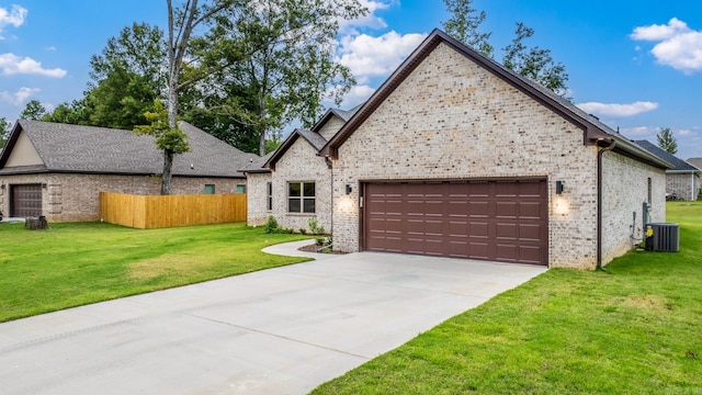 view of front of home featuring brick siding, an attached garage, a front yard, fence, and driveway