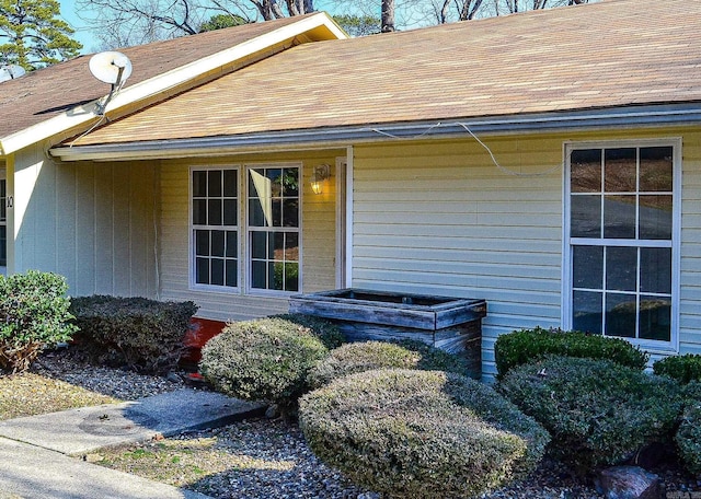 doorway to property with roof with shingles