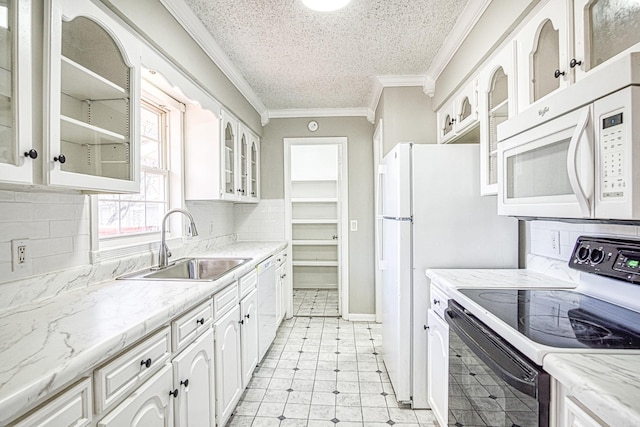 kitchen with white appliances, a sink, glass insert cabinets, and white cabinets