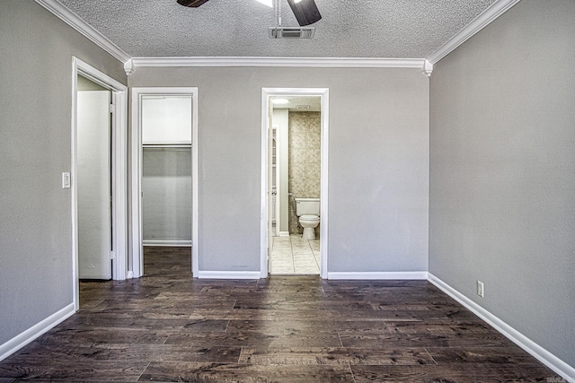 unfurnished bedroom featuring dark wood-style floors, a closet, visible vents, ornamental molding, and a textured ceiling