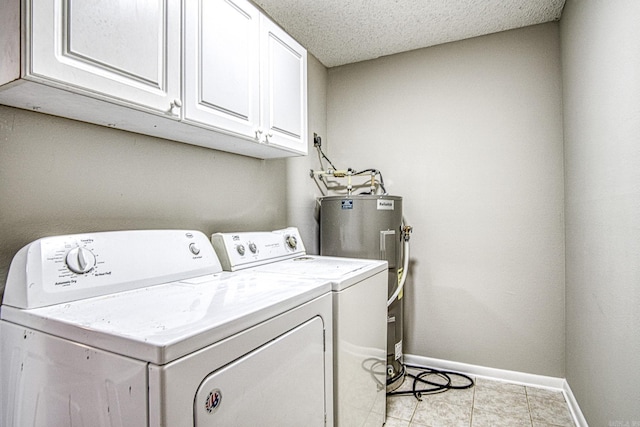 laundry area with cabinet space, baseboards, electric water heater, washing machine and clothes dryer, and a textured ceiling