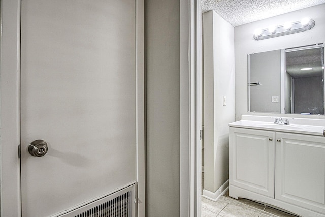 bathroom featuring a textured ceiling, vanity, and tile patterned floors