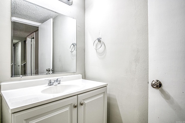 bathroom featuring a textured ceiling and vanity