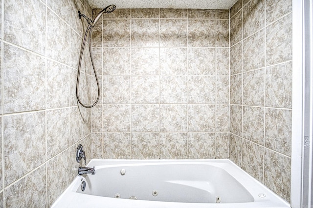 bathroom with a combined bath / shower with jetted tub and a textured ceiling