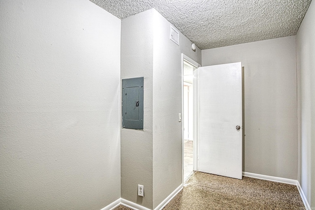 corridor with electric panel, baseboards, a textured wall, a textured ceiling, and carpet floors