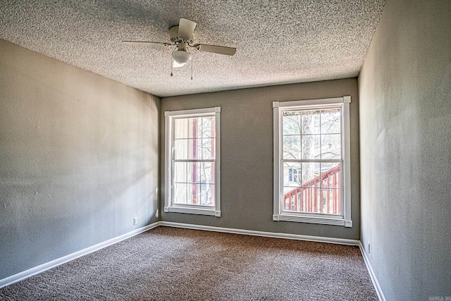 unfurnished room with carpet floors, a textured wall, ceiling fan, a textured ceiling, and baseboards