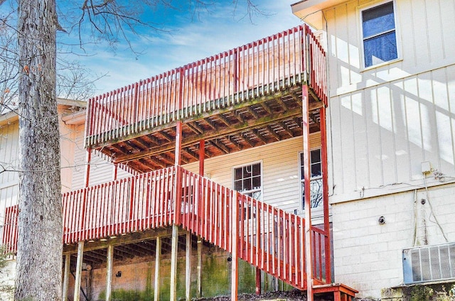 view of side of property with stairs and cooling unit