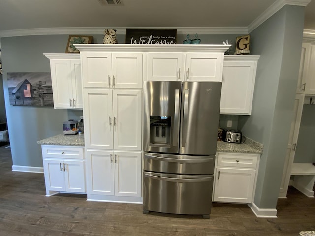 kitchen with light stone counters, dark wood-style floors, crown molding, white cabinetry, and stainless steel fridge with ice dispenser