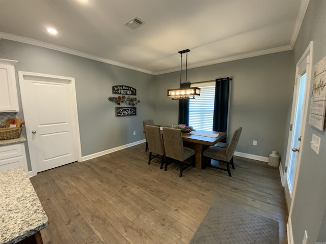 dining space with a chandelier, visible vents, baseboards, ornamental molding, and dark wood finished floors