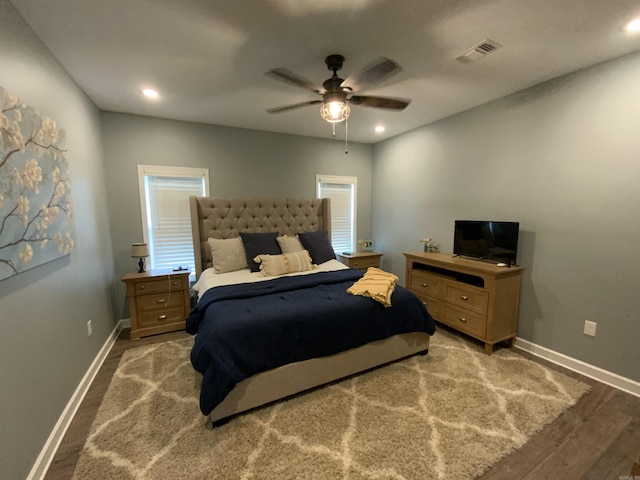 bedroom featuring wood finished floors, visible vents, and baseboards