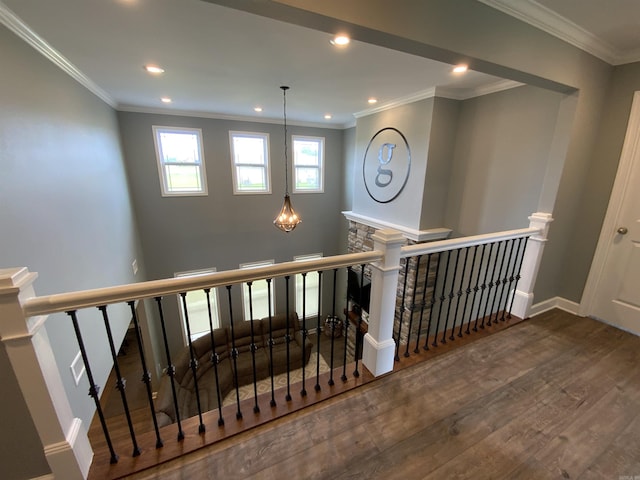 stairway featuring a notable chandelier, recessed lighting, wood finished floors, baseboards, and crown molding