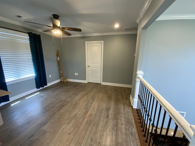 unfurnished room featuring ornamental molding, dark wood finished floors, visible vents, and baseboards