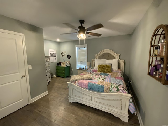 bedroom with dark wood-style floors, a ceiling fan, and baseboards