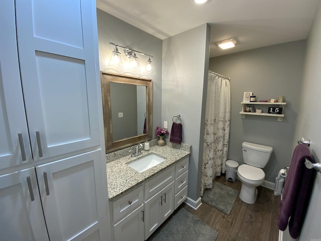 full bath with toilet, wood finished floors, vanity, and baseboards