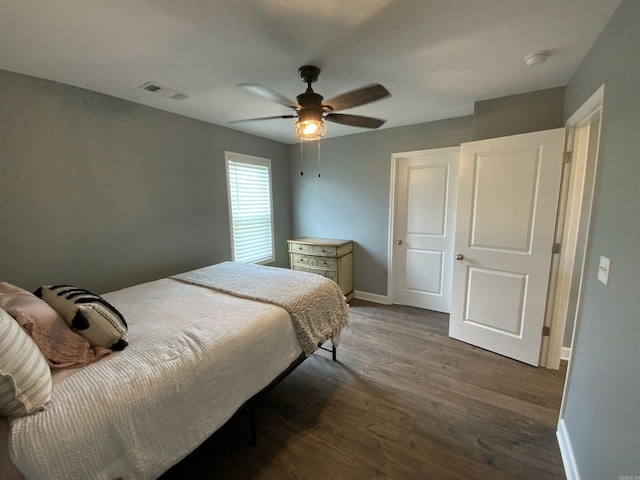 bedroom featuring dark wood-style floors, baseboards, visible vents, and ceiling fan