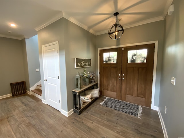 foyer entrance with baseboards, wood finished floors, and ornamental molding