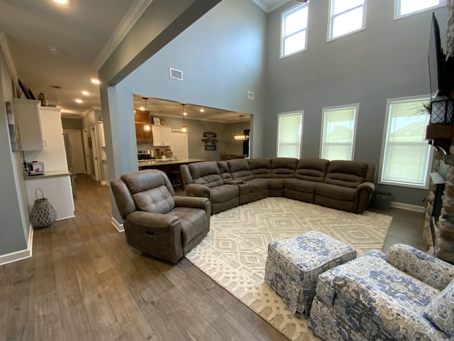 living room with baseboards, visible vents, ornamental molding, wood finished floors, and recessed lighting