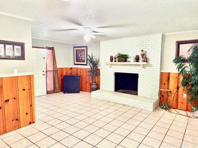 840 S 16th St, Arkadelphia, AR 71923 - living room featuring a textured ceiling, a wainscoted wall, wood walls, a ceiling fan, and a brick fireplace