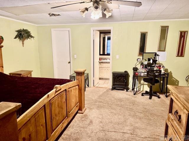 840 S 16th St, Arkadelphia, AR 71923 - bedroom with light carpet, ensuite bath, ceiling fan, ornamental molding, and a wood stove