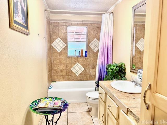 840 S 16th St, Arkadelphia, AR 71923 - bathroom featuring ornamental molding, shower / bath combination with curtain, a textured ceiling, and toilet