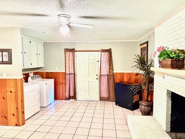 840 S 16th St, Arkadelphia, AR 71923 - laundry room with a textured ceiling, light tile patterned floors, wooden walls, a wainscoted wall, and separate washer and dryer