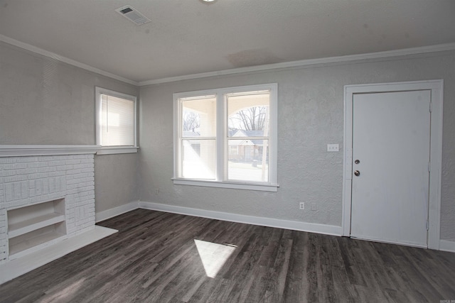 unfurnished living room featuring dark wood-type flooring, visible vents, baseboards, ornamental molding, and a brick fireplace