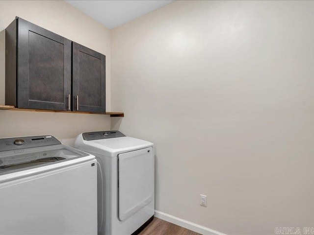 clothes washing area featuring cabinet space, baseboards, dark wood finished floors, and independent washer and dryer