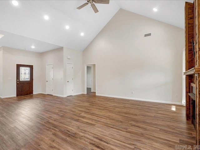 unfurnished living room featuring ceiling fan, visible vents, a fireplace, and wood finished floors