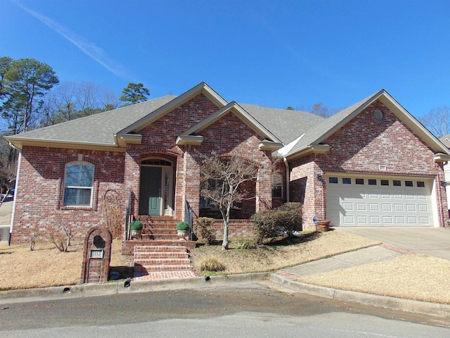 ranch-style house with a shingled roof, brick siding, driveway, and an attached garage