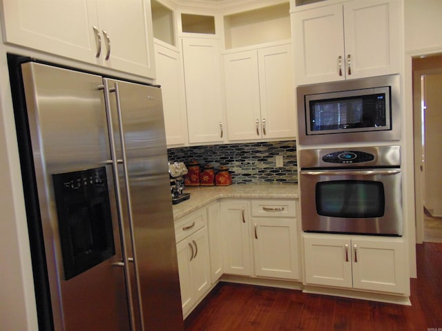 kitchen with stainless steel appliances, dark wood-type flooring, glass insert cabinets, and decorative backsplash