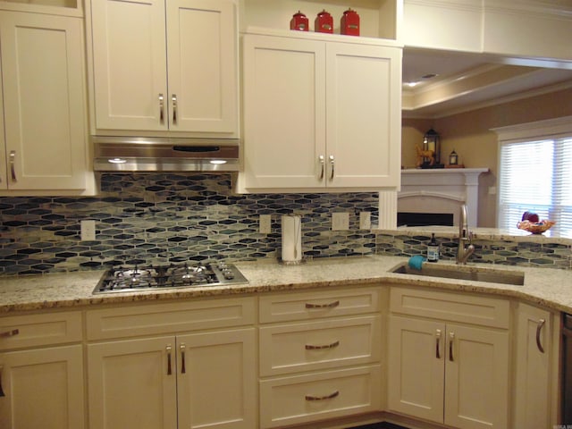 kitchen with stainless steel gas cooktop, a sink, range hood, tasteful backsplash, and crown molding