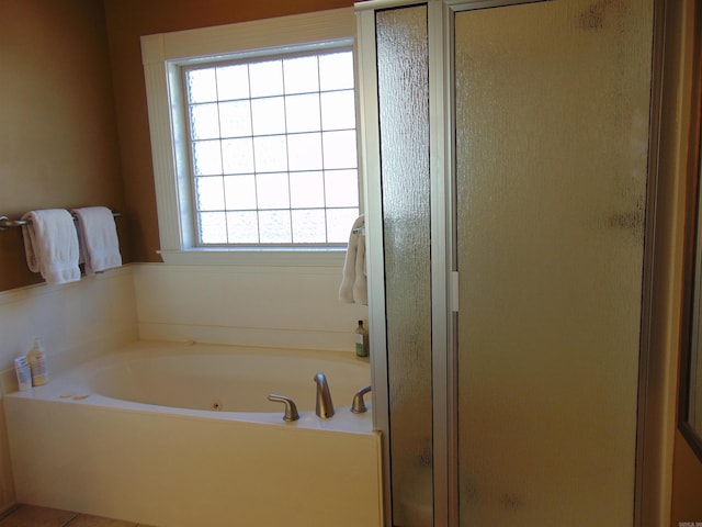 full bathroom with a garden tub and a shower stall