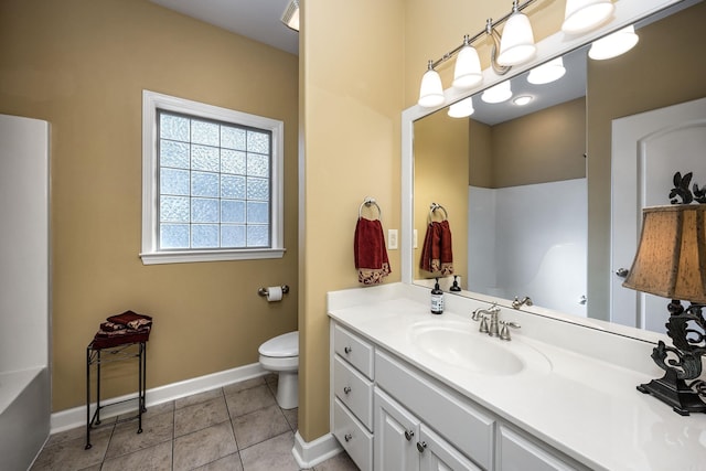 bathroom featuring toilet, vanity, baseboards, and tile patterned floors