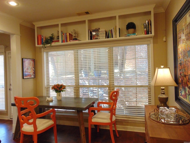 dining room featuring a healthy amount of sunlight, visible vents, wood finished floors, and ornamental molding