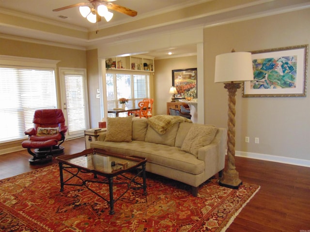 living room featuring baseboards, wood finished floors, a wealth of natural light, and crown molding