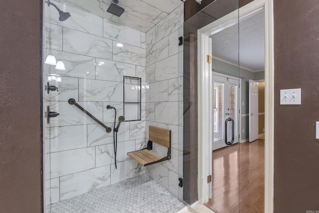 bathroom featuring a textured wall, a shower stall, and crown molding