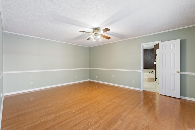 empty room featuring ceiling fan, a textured ceiling, baseboards, and wood finished floors