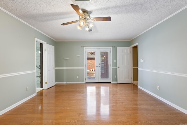 unfurnished room featuring french doors, crown molding, light wood-style flooring, and baseboards