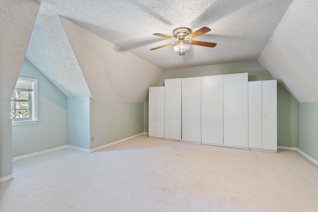 additional living space with vaulted ceiling, ceiling fan, a textured ceiling, and baseboards