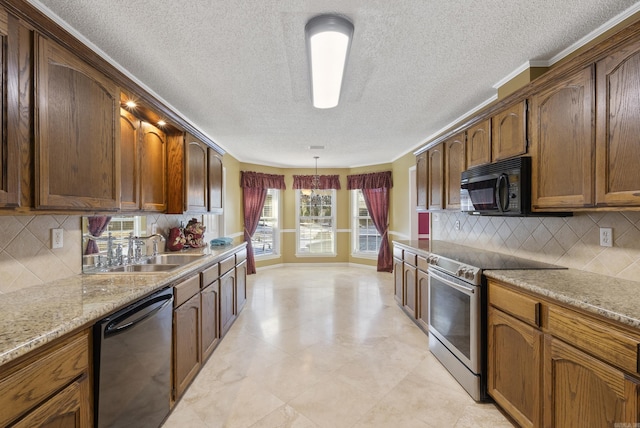 kitchen featuring a sink, hanging light fixtures, appliances with stainless steel finishes, backsplash, and light stone countertops