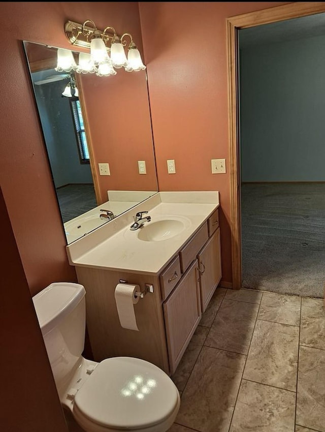 half bathroom with tile patterned flooring, vanity, and toilet