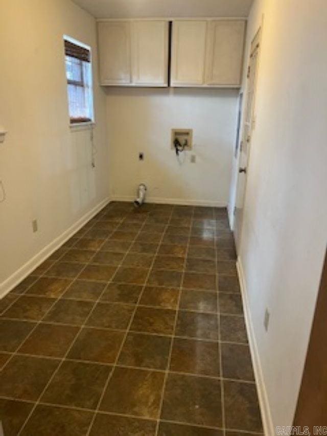 washroom with cabinet space, baseboards, dark tile patterned flooring, hookup for a washing machine, and electric dryer hookup